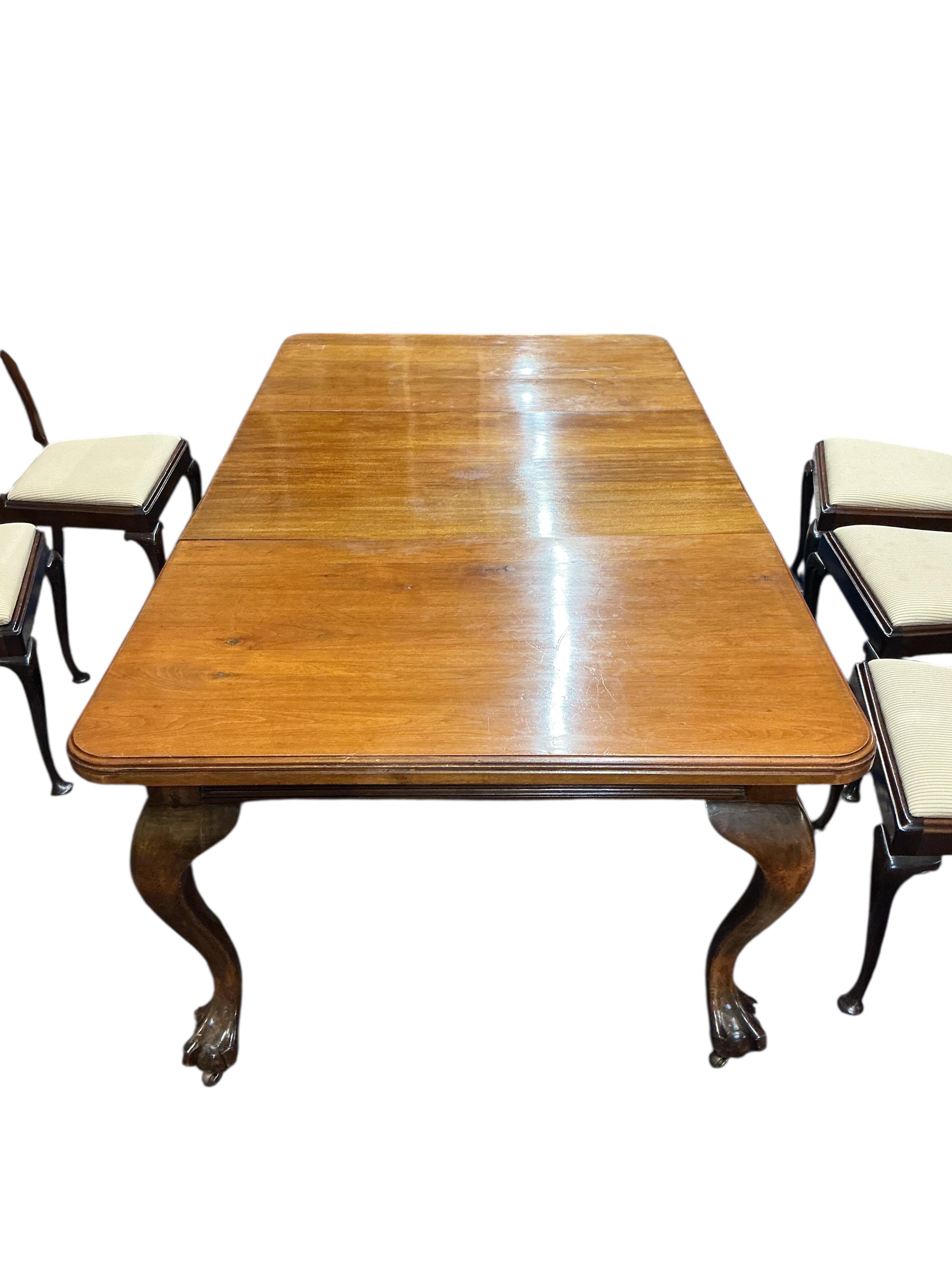 A 1920's mahogany extending dining table 206cm extended, one spare leaf, and eight Queen Anne style mahogany dining chairs, two with arms